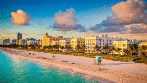 "Golden hour at South Beach Miami showing Art Deco buildings, pristine shores, lifeguard stands and beachgoers under a dramatic October sky"