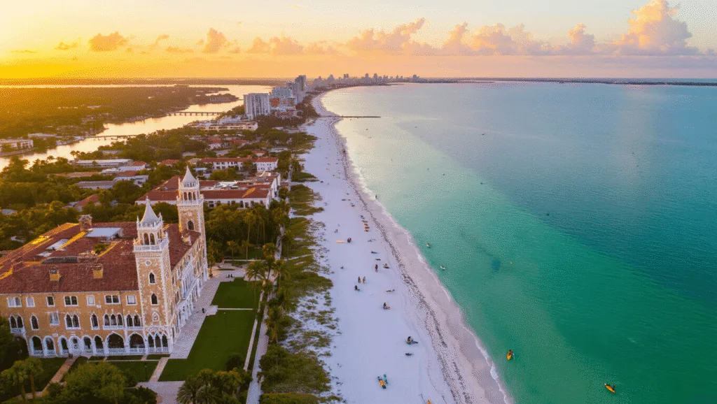"Aerial panoramic view of Sarasota coast at golden hour featuring Ringling Museum Complex and Ca' d'Zan Mansion, Siesta Key's pristine beach, Sarasota Bay with kayakers and dolphins, Myakka River State Park, and Bay Park waterfront in photorealistic style."