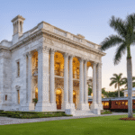 Why the Flagler Museum Is America's Most Stunning Mansion You Can Actually Tour (And What Most Visitors Miss) "Beaux-Arts mansion exterior of Flagler Museum's Whitehall estate in Palm Beach with Flagler's restored railroad car No. 91 in the modern pavilion, against a backdrop of golden hour lighting, palm trees, and distant Lake Worth."